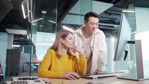 Asian Man and Woman Collaborating at a Computer