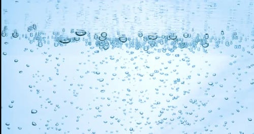 Many water bubbles in blue water close up, abstract water wave with bubbles in slow motion.