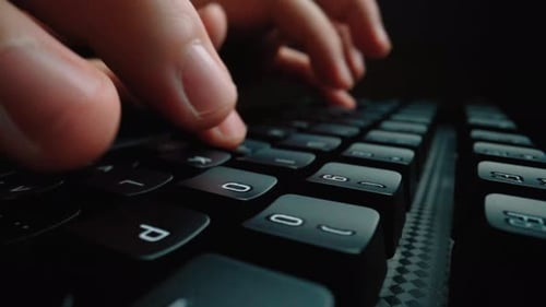Tippen in Nahaufnahme auf der Tastatur mit den Hauptfingern. Makro-Dolly-Aufnahme mit weichem Fokus. Glean