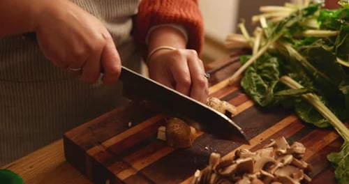 Woman Slices Mushrooms on Cutting Board at Home