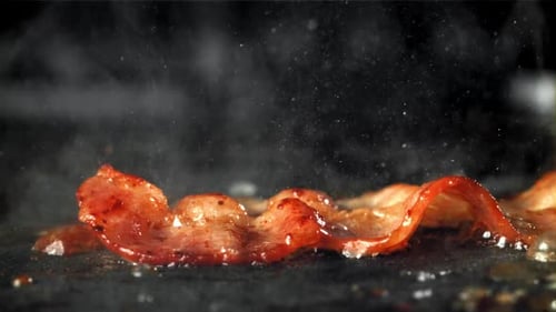 Delicious Bacon Sizzles in Pan with Vapor