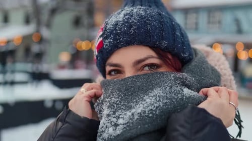 Smiling woman in winter hat and scarf in winter