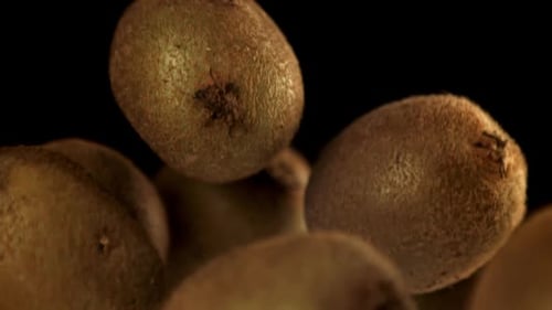 Kiwi Fruit Floating Against Black Background