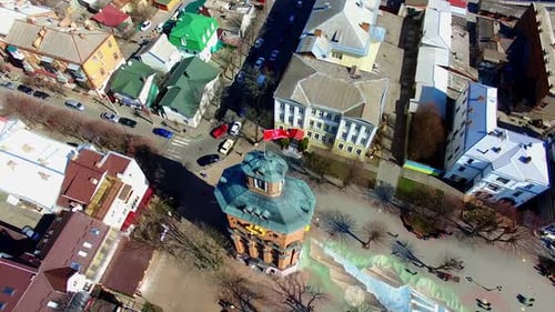 Square with a tower in the city park. Lots of people walk on sunny daytime. Top view.