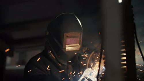 Welder Performing Metal Welding with Sparks Indoors