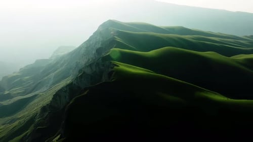 Majestic Mountain Peaks Emerge From the Ethereal Fog Enveloping the Tranquil Green Hills and