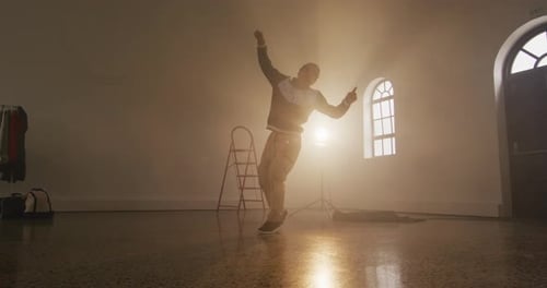 Portrait of biracial male dancer dancing in dance studio, slow motion