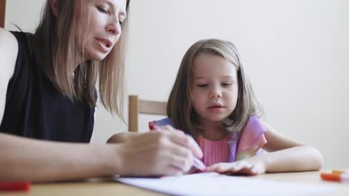 Woman and Child Drawing Together Indoors