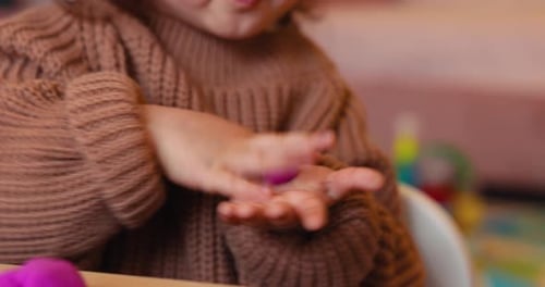 Child Playing with Purple Clay at Table