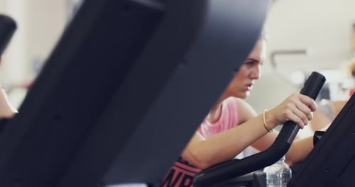 4k footage of a woman working out on an elliptical machine at the gym
