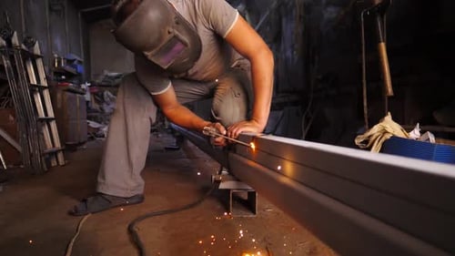 Young Repairman in Protective Mask Welding Iron Construction at Garage Manual Laborer with Welding