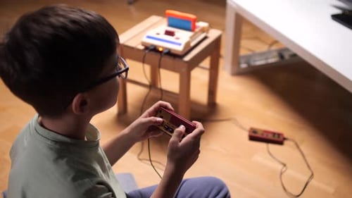 Child Plays Vintage Video Game at Home