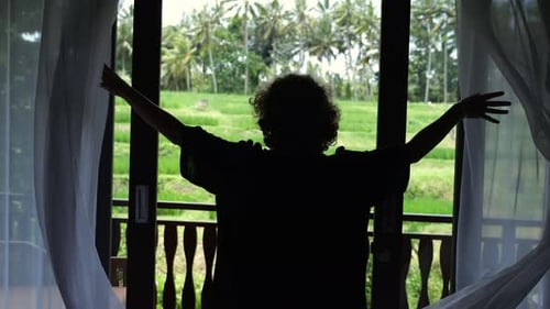 Young Woman Opens Curtains in Summer Hotel Silhouette Curlyhaired Blonde Opens Curtains in the