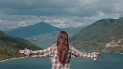 Woman Embracing Nature in Mountain Landscape