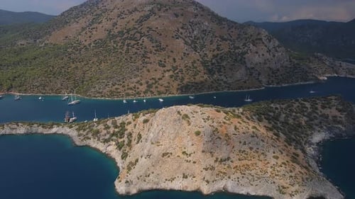 Aerial Shot Beautiful Blue Ocean with Rocky Coast and Yachts in the Bay