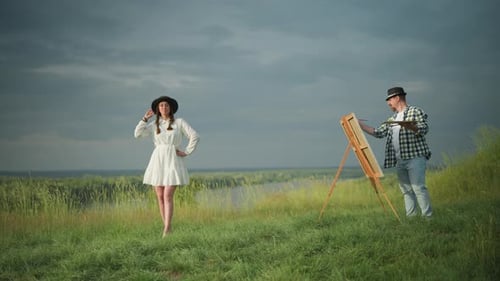Artist Painting Woman in White Dress and Hat By Lakeside Field
