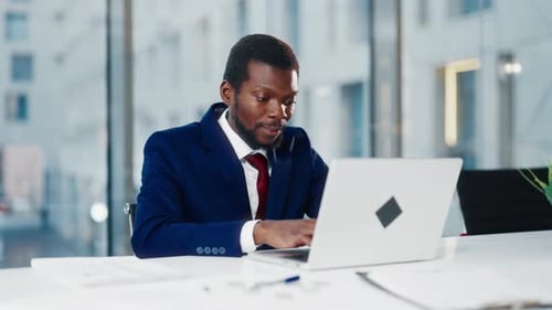 African American Businessman in Expensive Suit Opening Laptop in Office Portrait Successful Man
