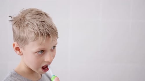 Young Child Brushing Teeth with Electric Toothbrush