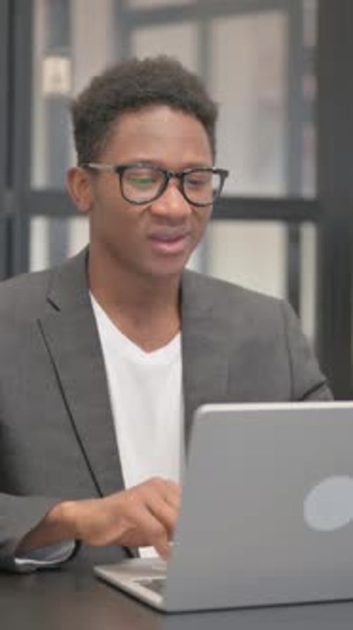 Young Man Attends Video Call with Laptop in Office