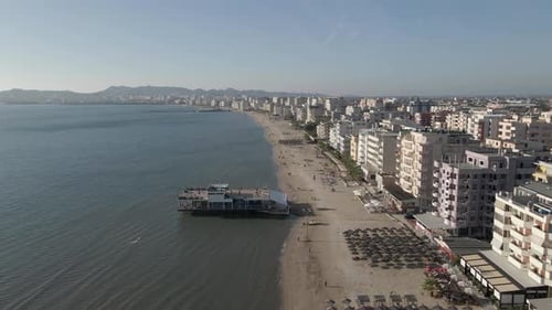 Low flight over beach restaurant pier on Adriatic coast of Albania