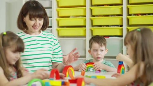 Teacher and Children Build with Rainbow Blocks