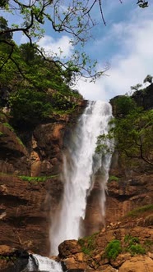 Beautiful waterfall and blue sky background. Vertical Video. Summer. Spring.