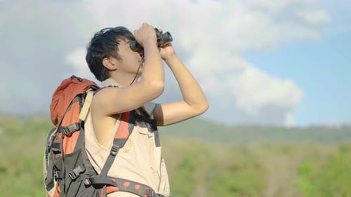 Man Hiker with Backpack Using Binoculars