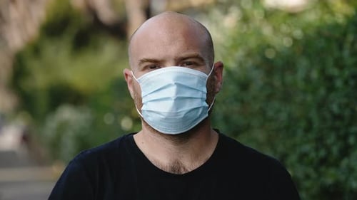 Man Putting on a Surgical Face Mask