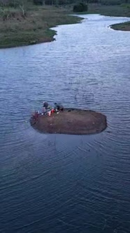 Drone survolant la petite île où deux pêcheurs pêchent calmement dans les lacs de Long Thanh au Vietnam