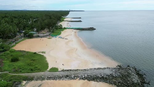 Viaduto com drone da praia de Kappad com mar calmo e caminho de pedra que se estende até a água