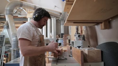 Carpenter Putting on Safety Goggles Before Using Table Saw in Workshop 3539 Years
