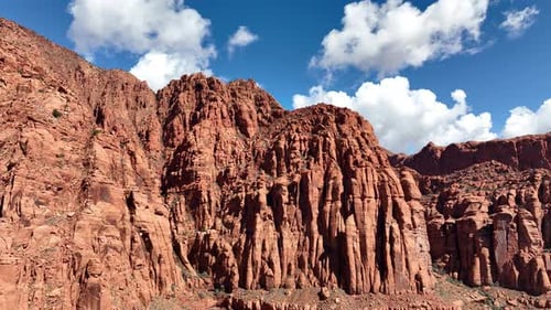 Luftaufnahme der Red Rocks Cliffs in der Wüste mit blauem Himmel und c weiße geschwollene Wolken
.