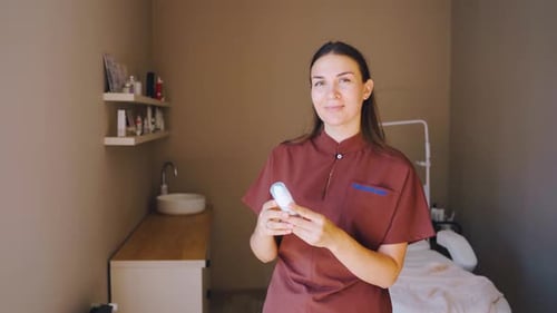 Skincare Specialist with Products Displayed Clinic Cosmetologist Showcasing Skincare Bottles in