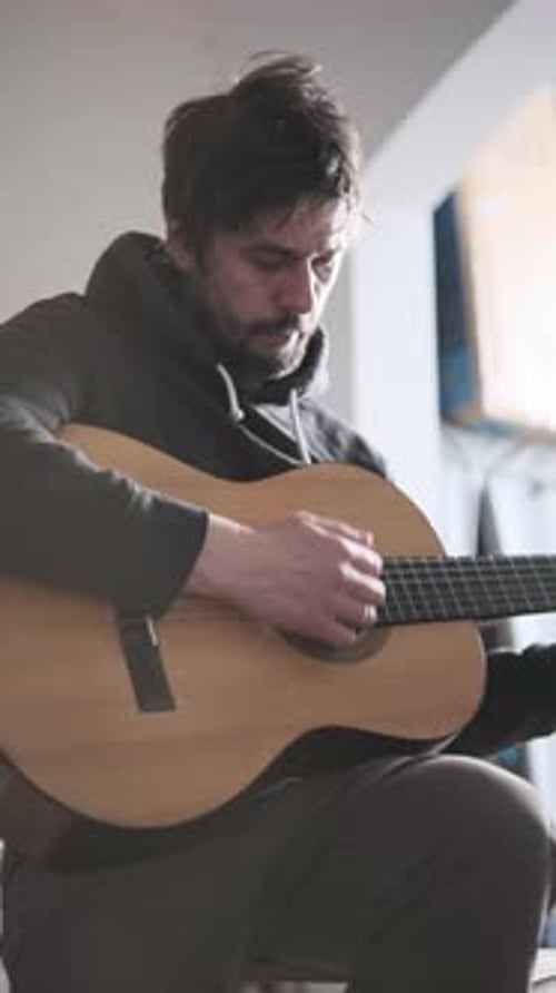 Man Plays Acoustic Guitar Indoors