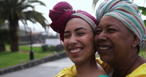 Smiling Women Wearing Colorful Head Wraps in Tropical Park