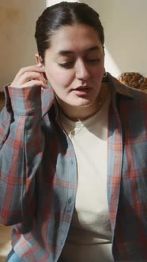 Businesswoman Using Earphones Video Calling on Laptop in Cafe