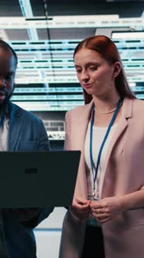 Vertical Video Engineering Team in Server Hub Working Together with Laptop to Do Maintenance