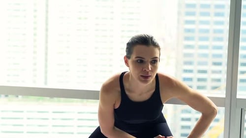 Woman stretching and exercising inside apartment