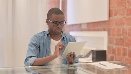 Young Adult Using Tablet at Counter Indoors