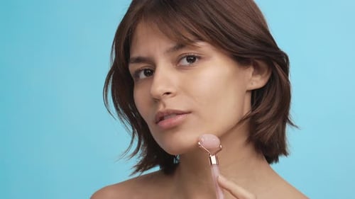 Beautiful Girl Using Jade Roller for Facial Massage