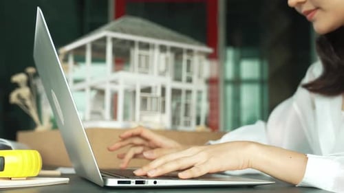 Jeune belle ingénieure vérifiant le matériau du toit et utilisant un ordinateur portable. Manipulateur.