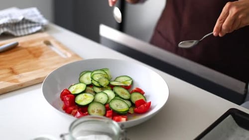 Bowl of Tomatoes and Cucumbers Being Mixed