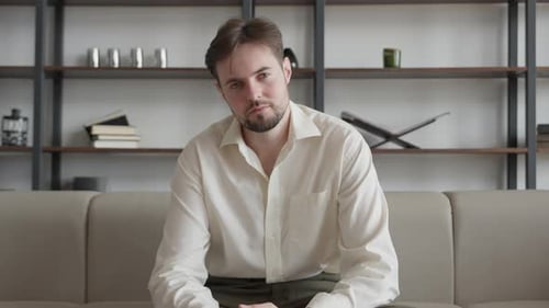 Young Adult Sitting on Couch Looking At Camera