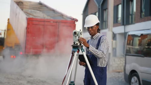 Ingénieur géomètre afro-américain travaillant sur un chantier de construction