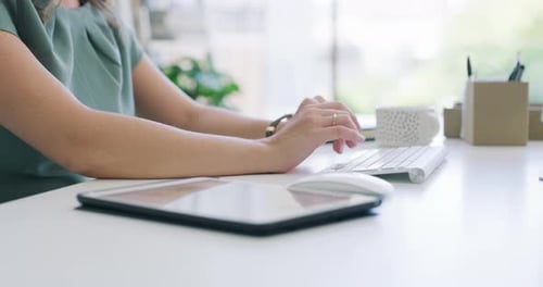 Woman Working at Desk With Keyboard and Tablet
