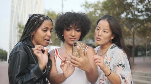 Happy Trans Woman with Two Multiethnic Friends Using the Mobile in the Street