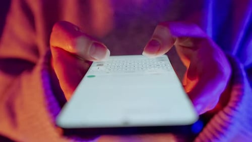 Hands Typing on Modern Smartphone at Night