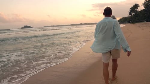 Young Man Walking on Beach During Sunset Super 240