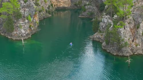 Aerial View Exploring the Beauty of a Lush Green Canyon By Paddleboard