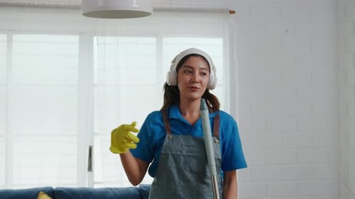 Smiling Woman Dancing While Cleaning Home